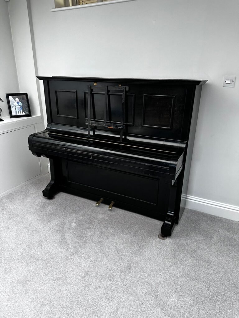 piano removals Manchester team protecting an upright piano before moving